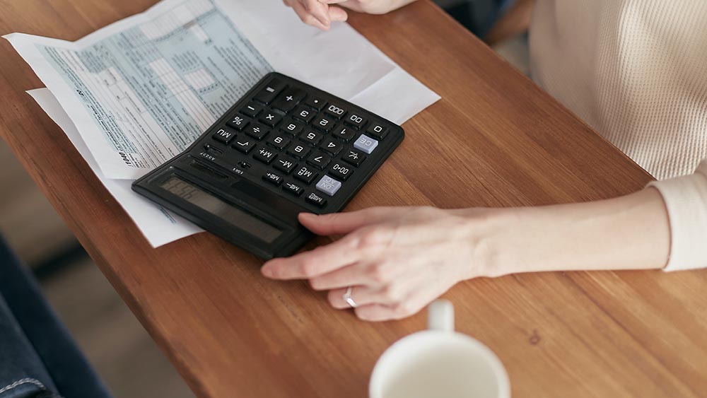 picture of a person looking at their bill with a calculator